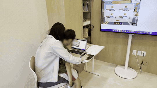 선생님과 아이가 화면 속 영어 프로그램을 함께 연습하는 모습